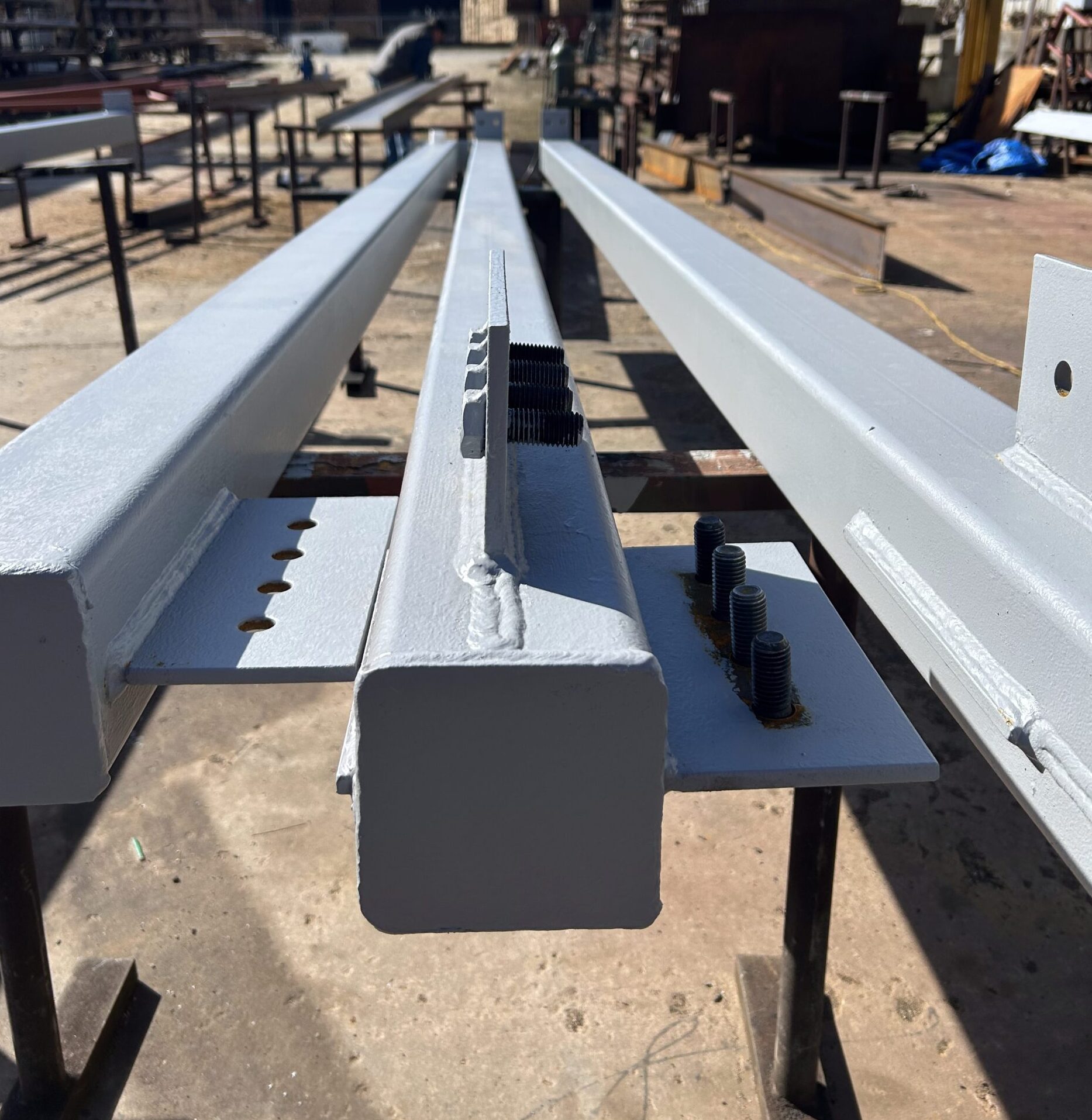 Custom fabricated structural steel beams with primer coating and hardware Franklin Machine Co. steel fabrication shop in Franklin, NC